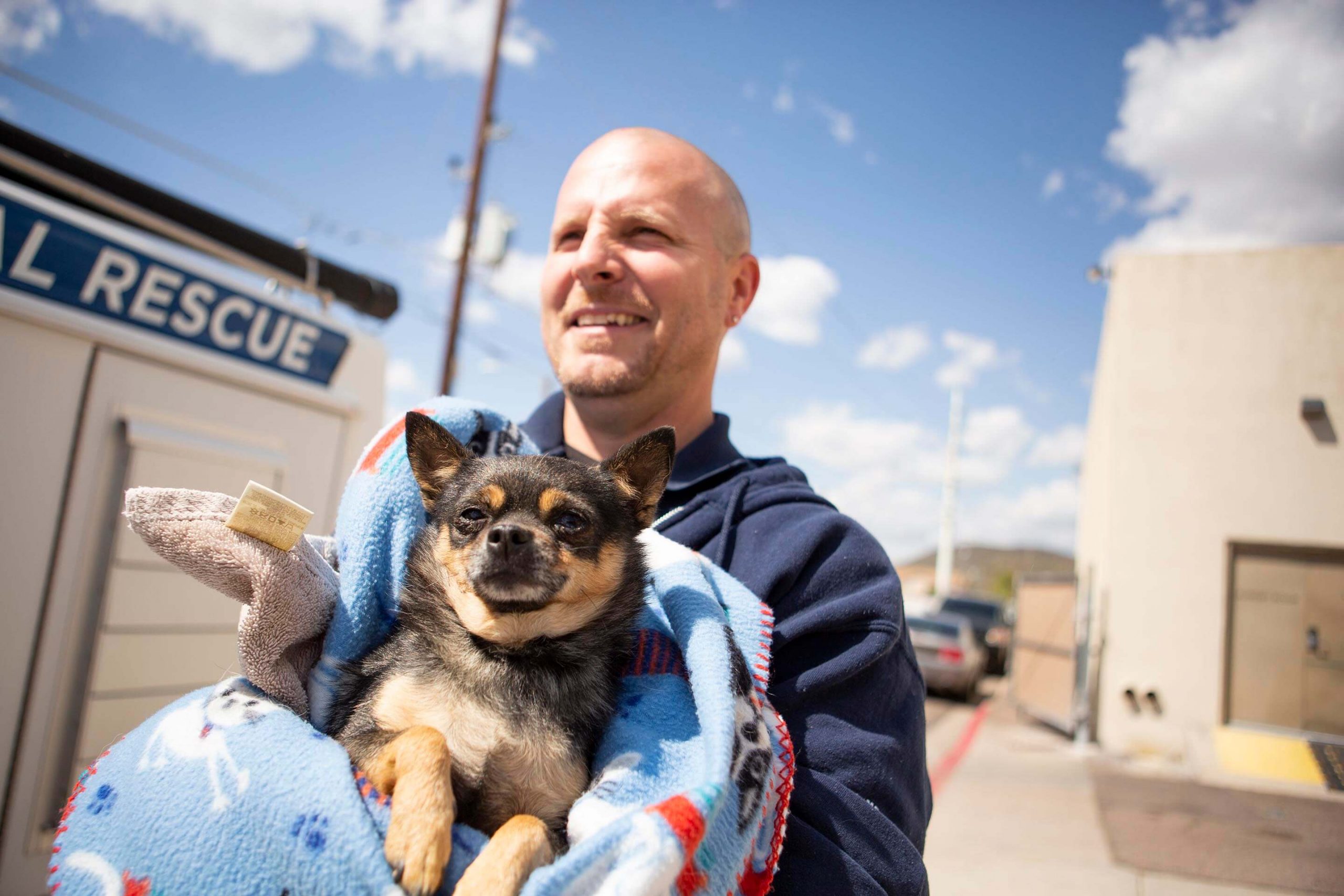 EAMT holding small dog in blanket