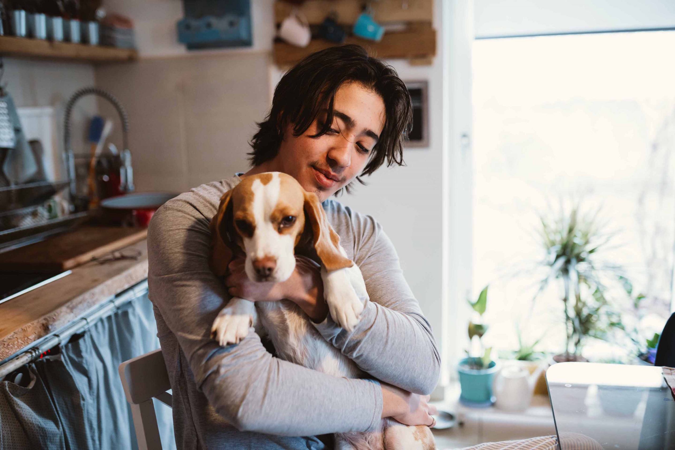 young man holds dog